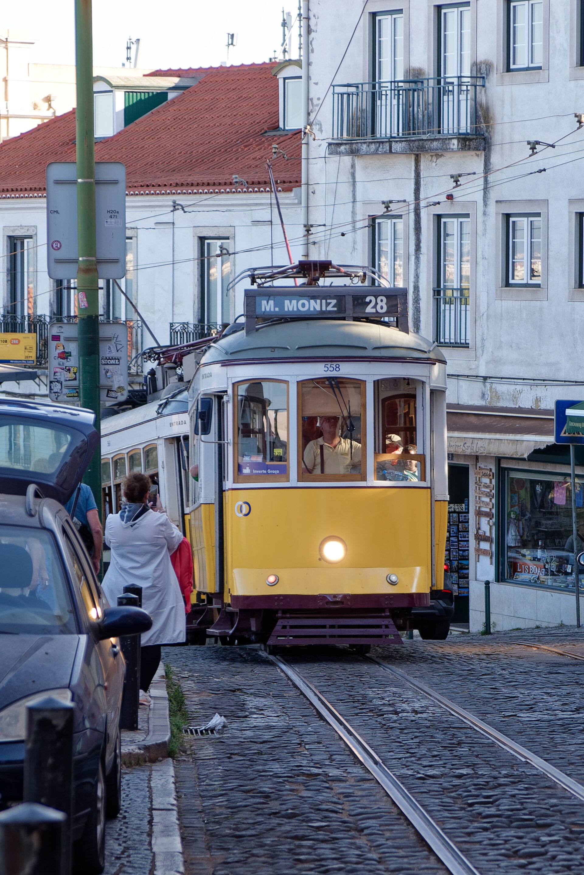 Classic yellow tram 28 winding through Lisbon's city streets
